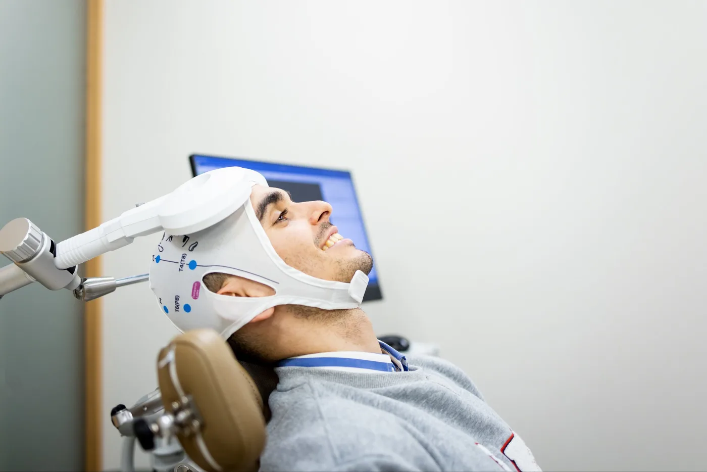 young Caucasian man between 20 and 30 years old undergoes transcranial magnetic stimulation therapy